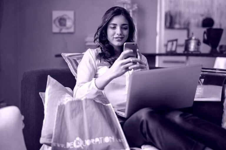 Clienta comprando desde el móvil y el portátil en el sofá